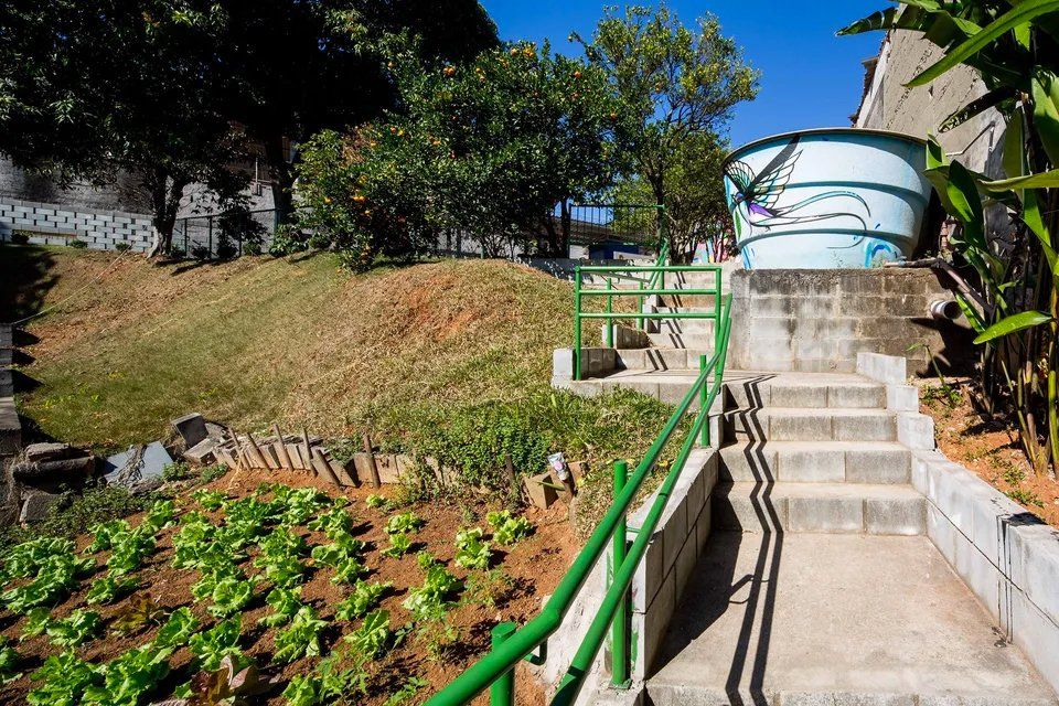 Uma escada que conduz a um grande tanque num jardim.