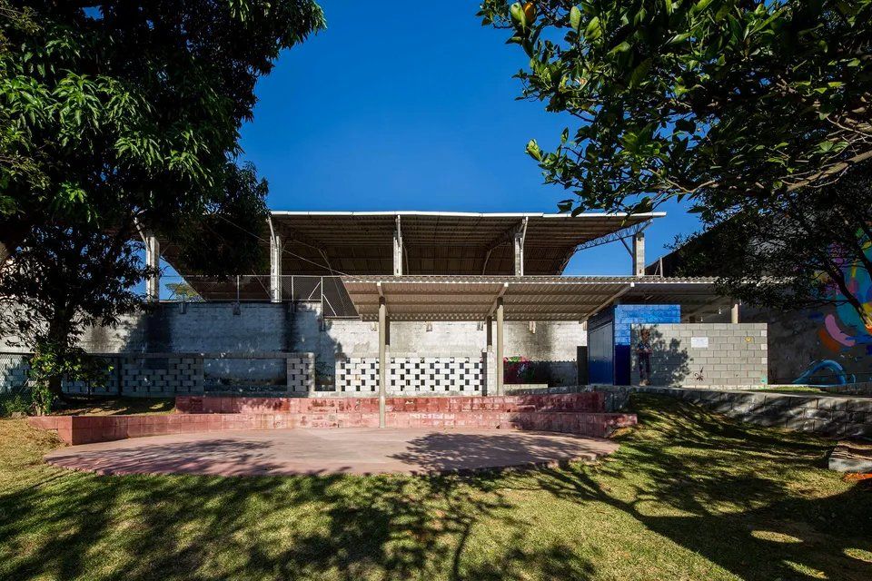 Um grande edifício está situado no meio de um parque cercado por árvores.