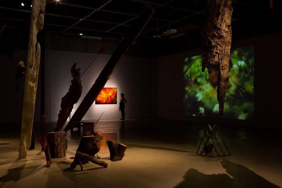 Uma sala escura com muitas esculturas e pinturas na parede.