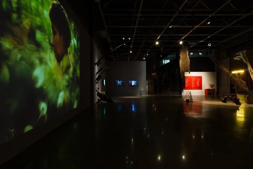 Uma sala escura com uma tela de projetor na parede.