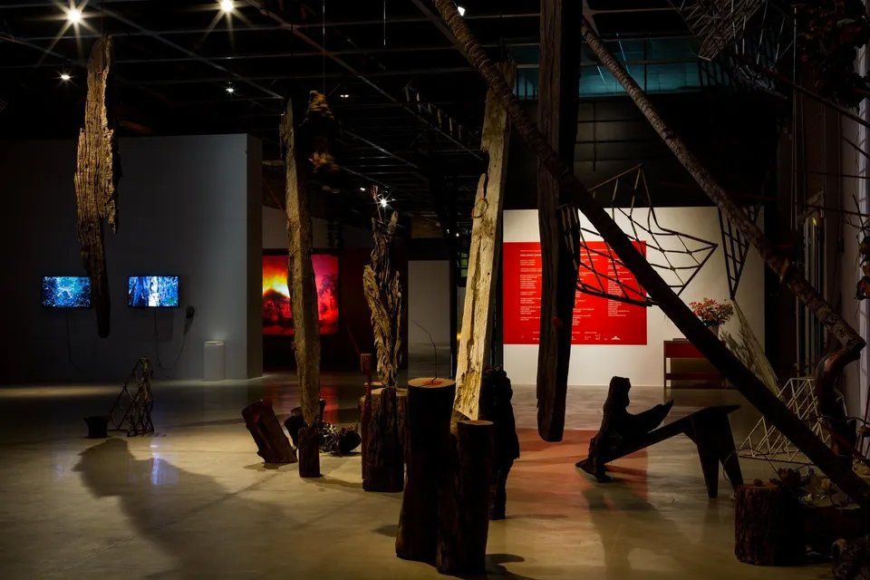 Uma sala com muitas esculturas de tocos de madeira.