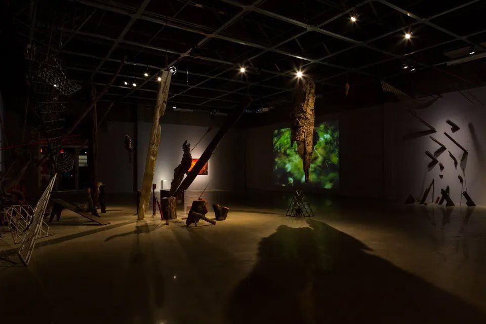 Uma sala escura com muitas esculturas no chão.