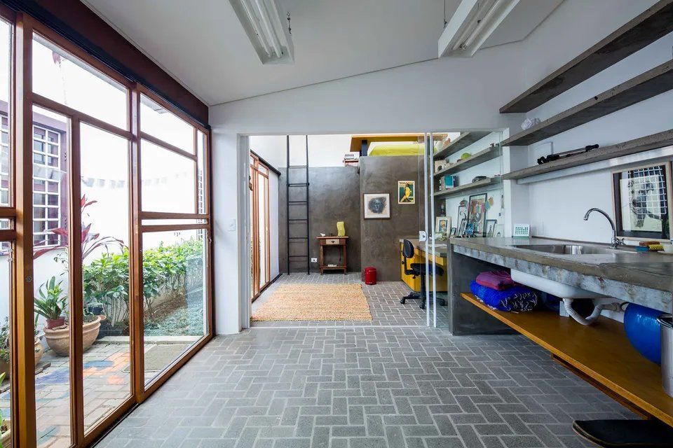 Um quarto com muitas janelas e piso de tijolos