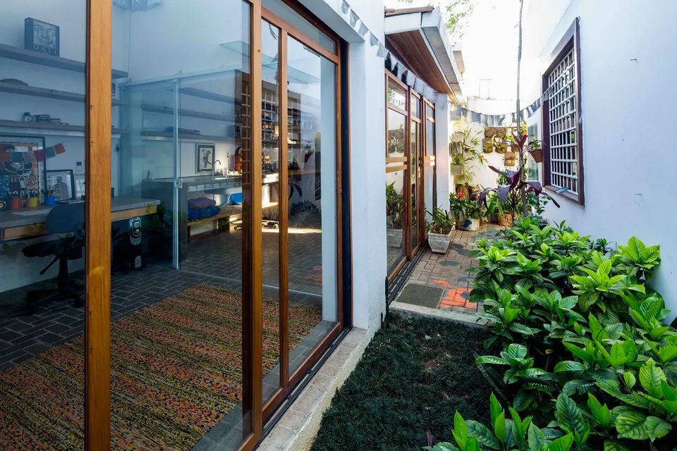 Uma casa com muitas janelas e plantas