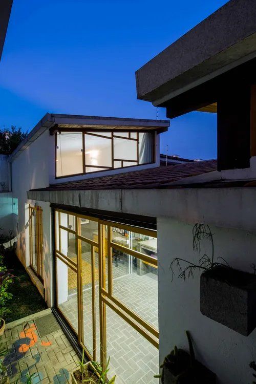 Uma casa com muitas janelas e um céu azul ao fundo