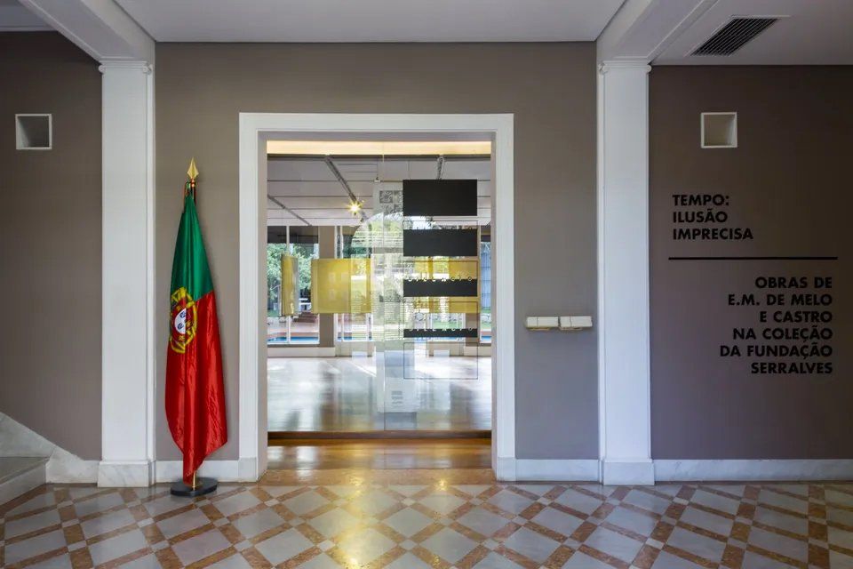 Uma bandeira portuguesa está em frente a uma placa que diz tempo