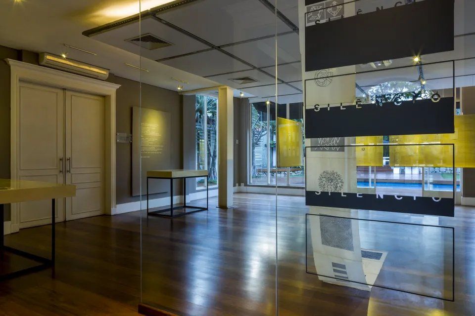 Uma grande sala vazia com piso de madeira e parede de vidro.