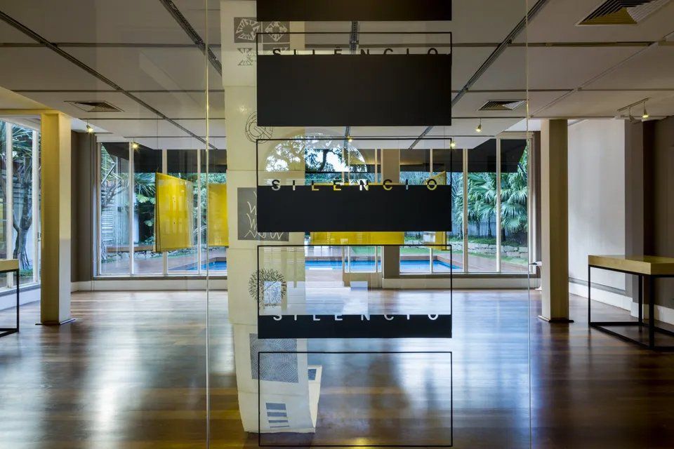 Uma sala com muitas janelas e piso de madeira.