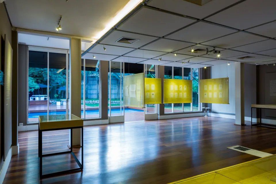 Uma sala grande com muitas janelas e piso de madeira