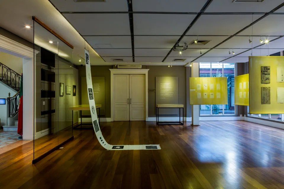 Uma grande sala com piso de madeira e parede de vidro