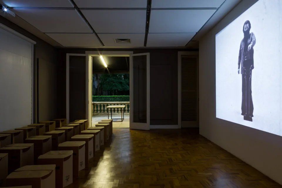 Uma sala com tela de projeção e caixas no chão