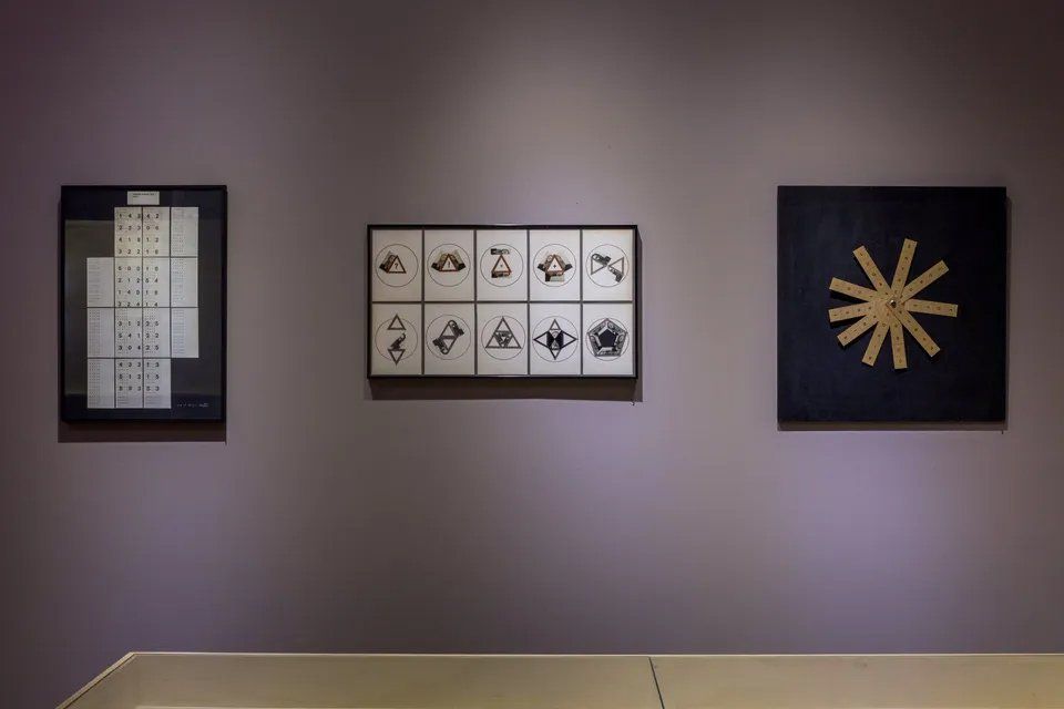 Três pinturas estão penduradas na parede de uma sala.