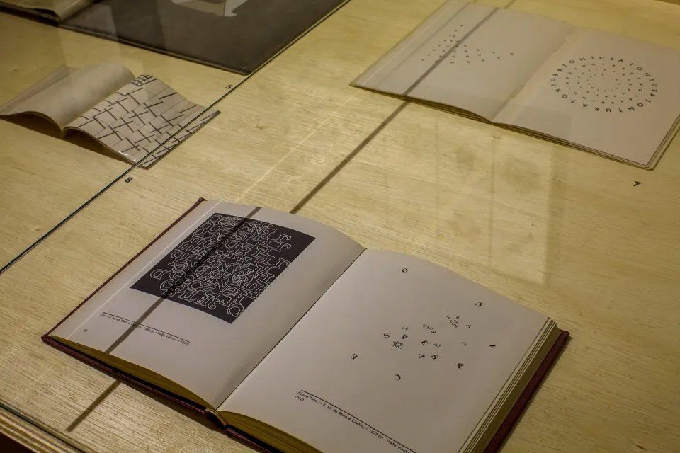 Vários livros estão abertos sobre uma mesa de madeira