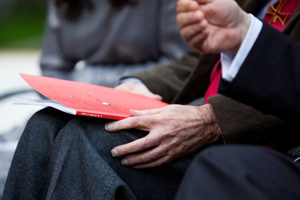 Um homem de terno e gravata está segurando uma pasta vermelha