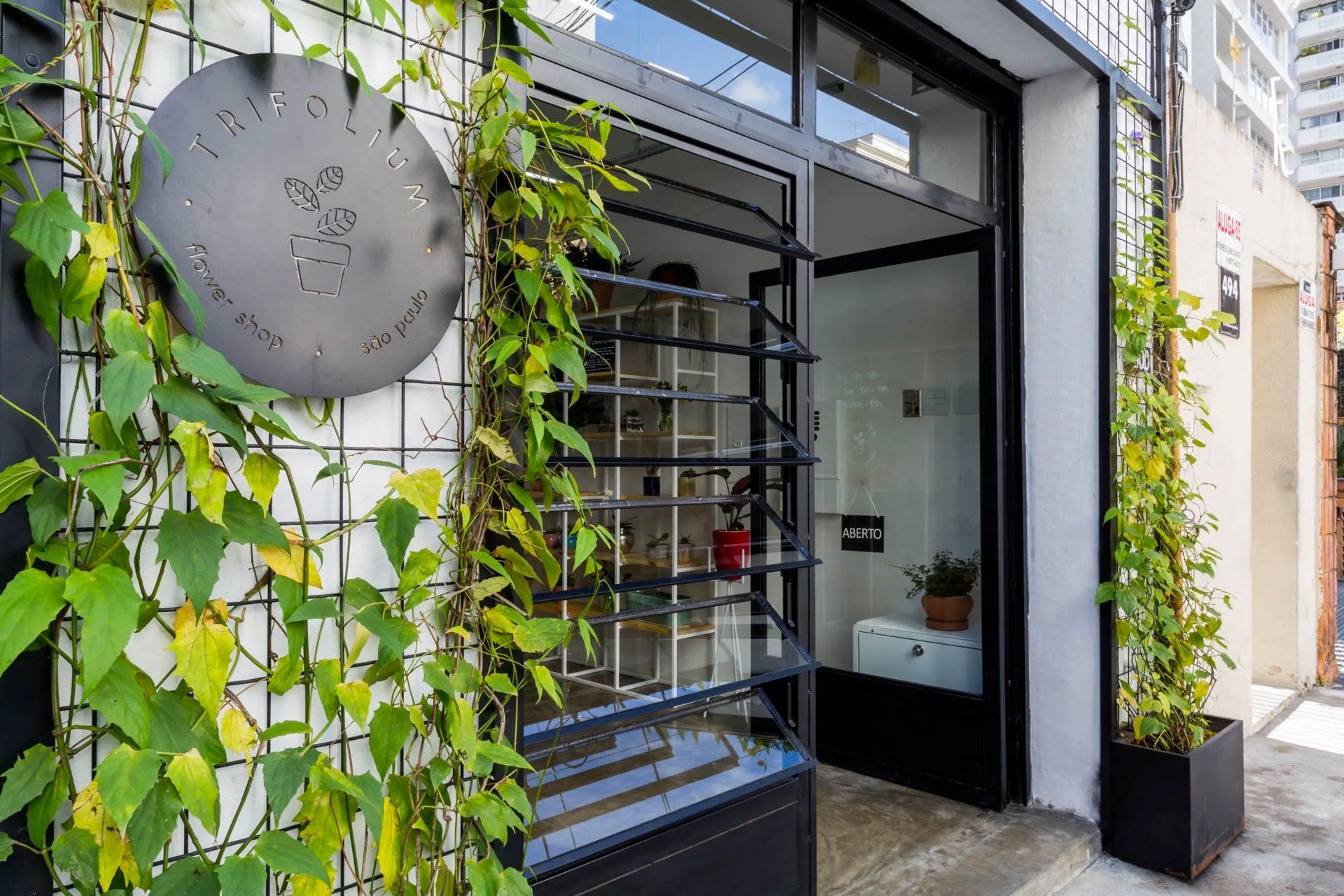 A frente de um prédio com plantas crescendo nas laterais.