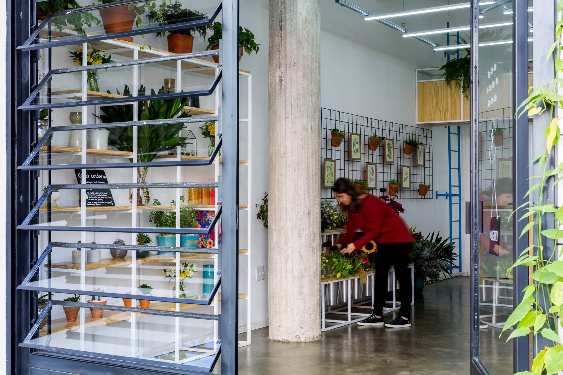 Uma mulher está trabalhando em uma floricultura.