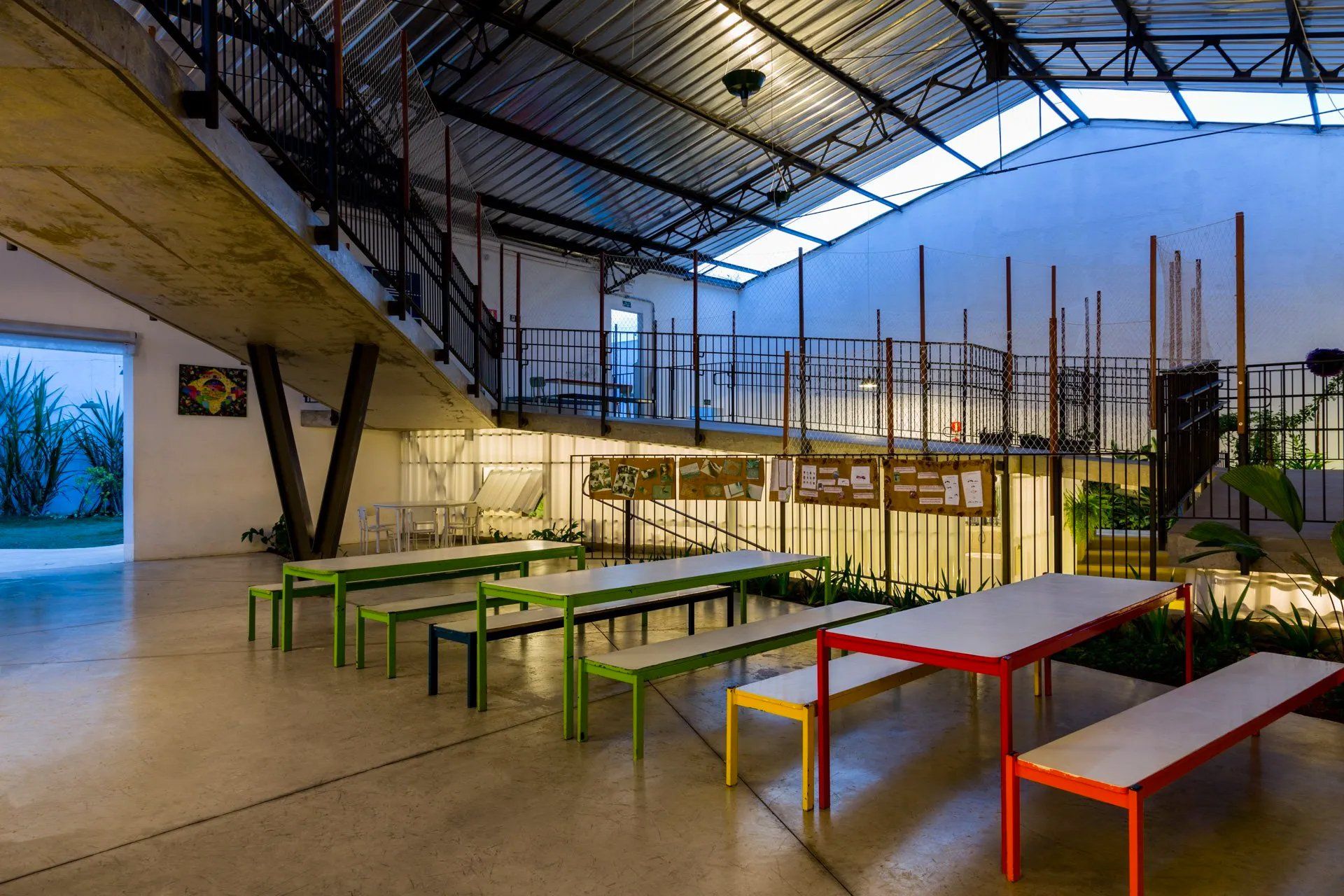 Uma grande sala com mesas e bancos.