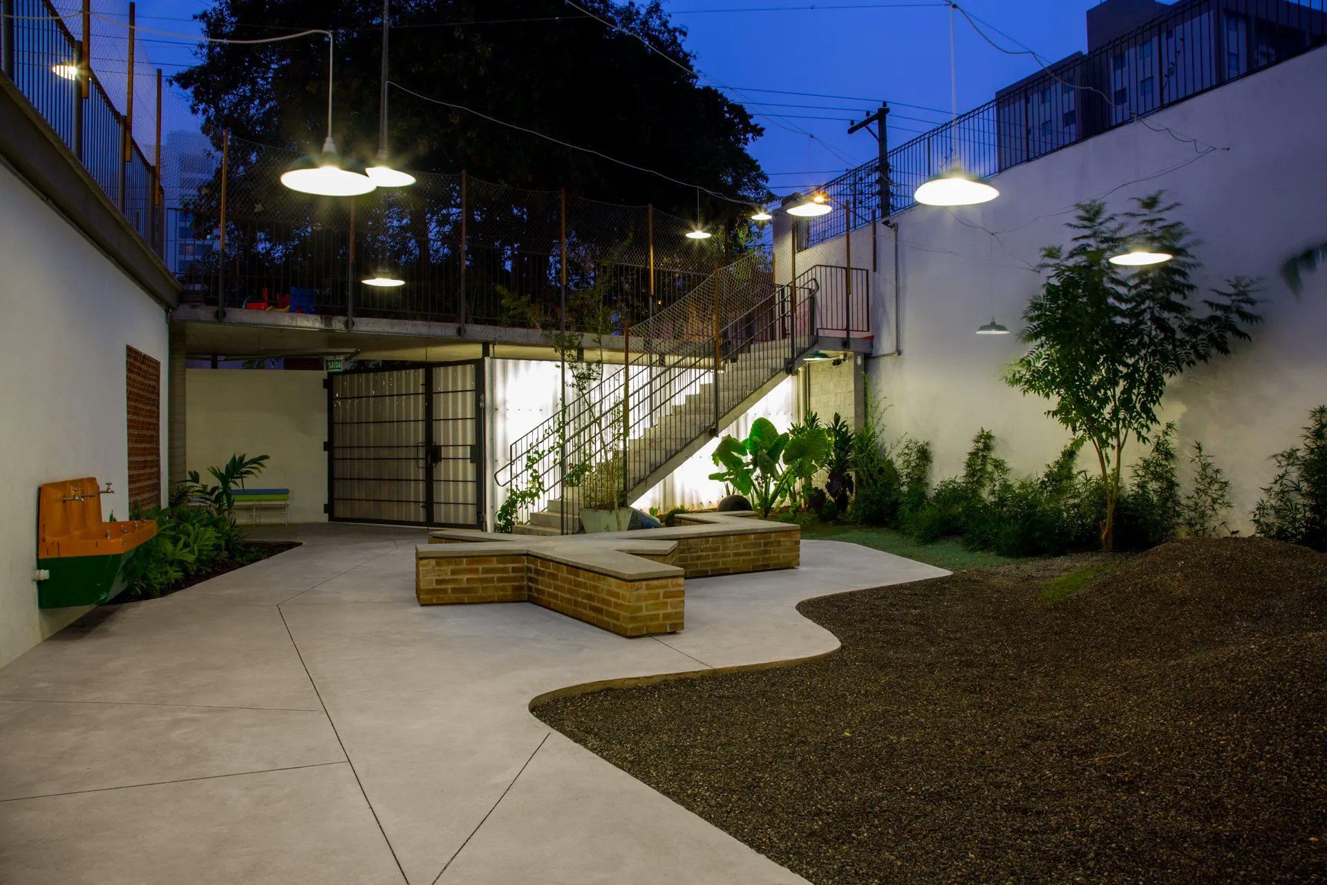 Um pátio com uma escada que conduz a um edifício à noite.