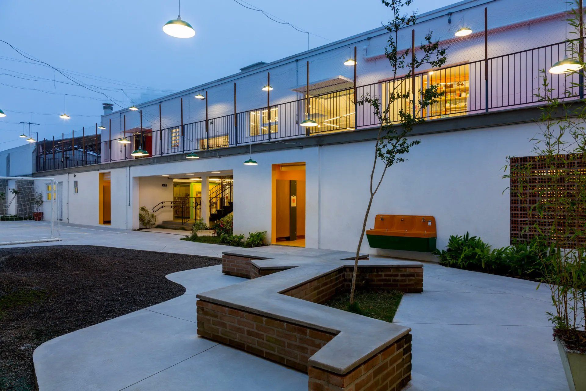 Um grande prédio branco com um banco de tijolos na frente.