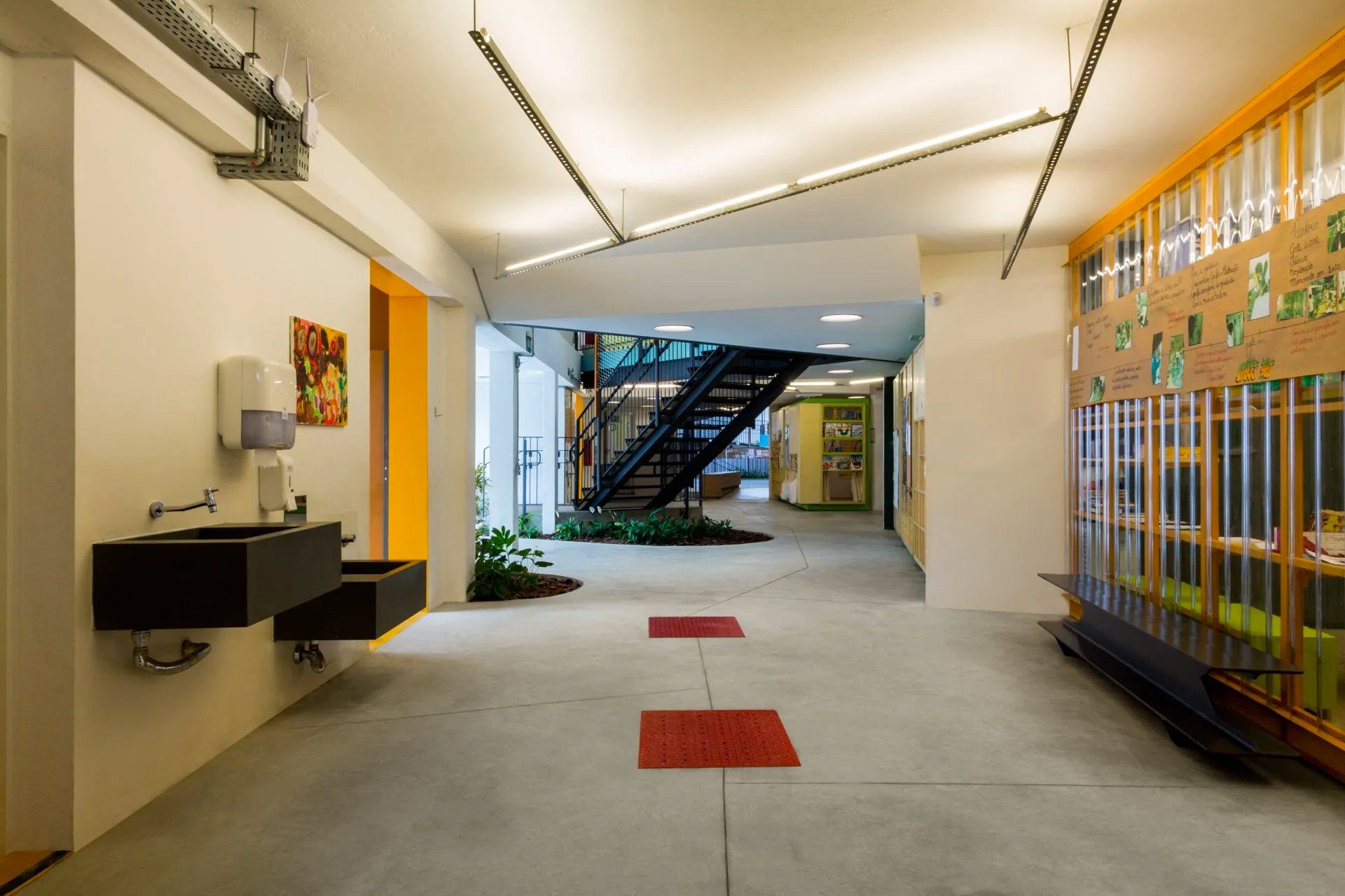 Um corredor com pia e escadas em um prédio.