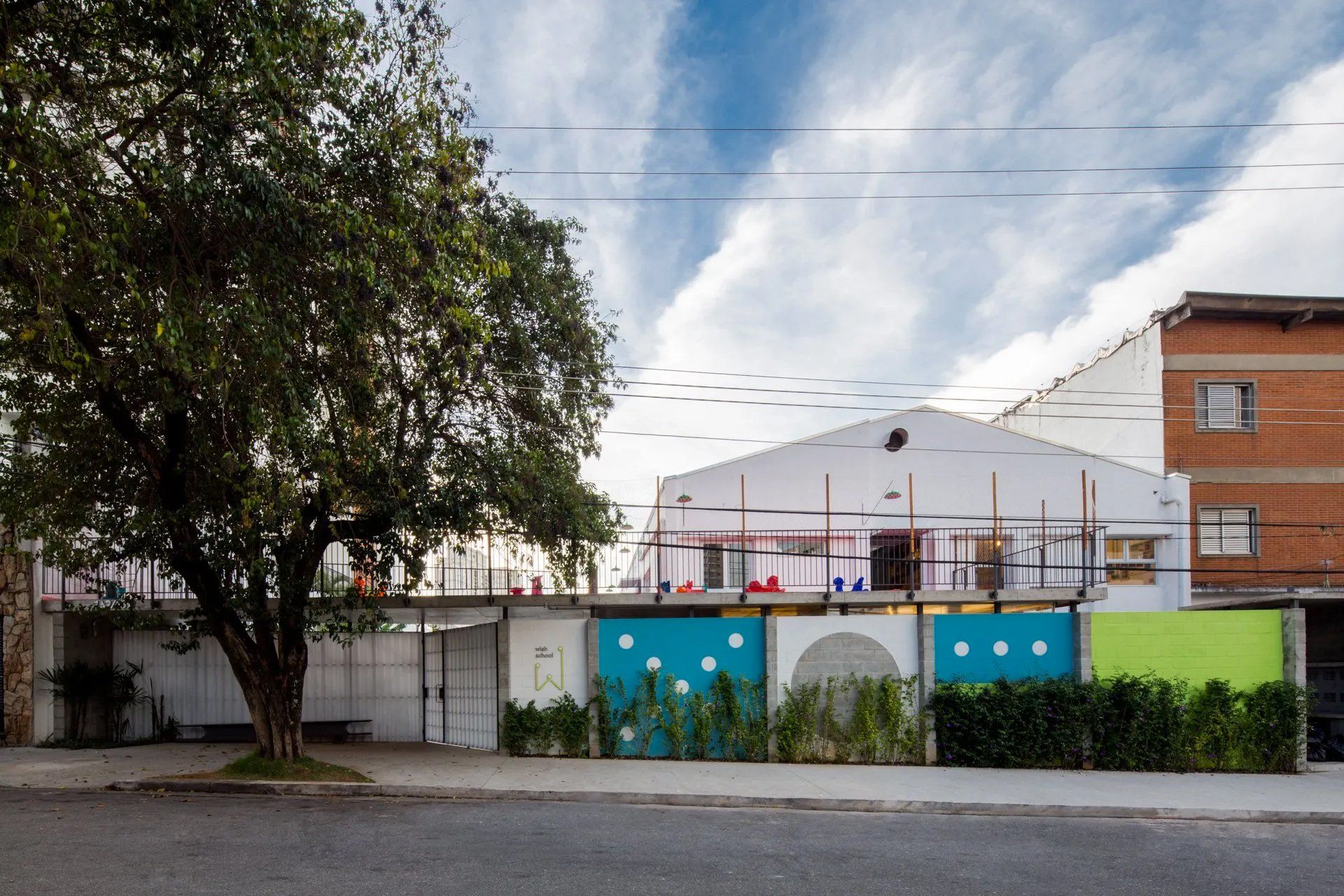 Um grande edifício com uma árvore na frente