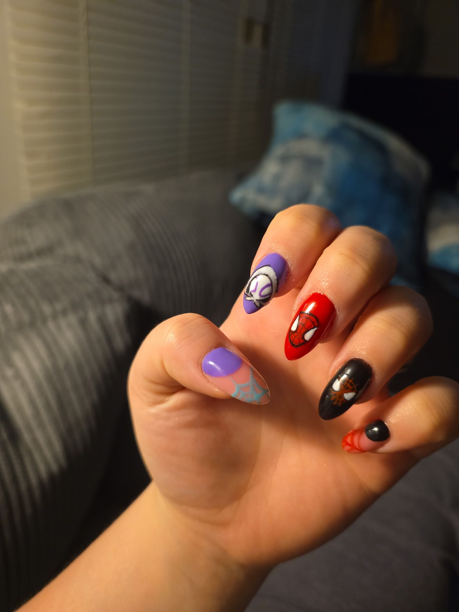 A close up of a person 's hand with spiderman nails.