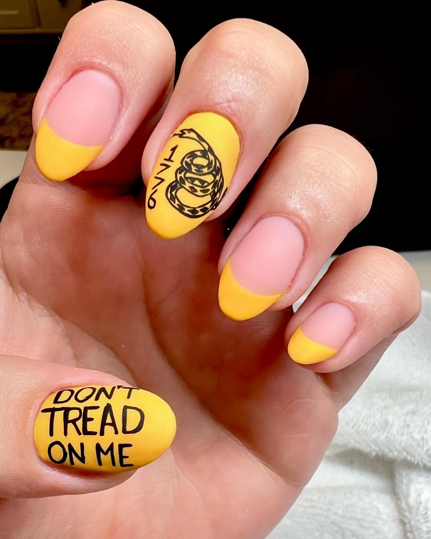 A close up of a person 's nails that say do n't tread on me