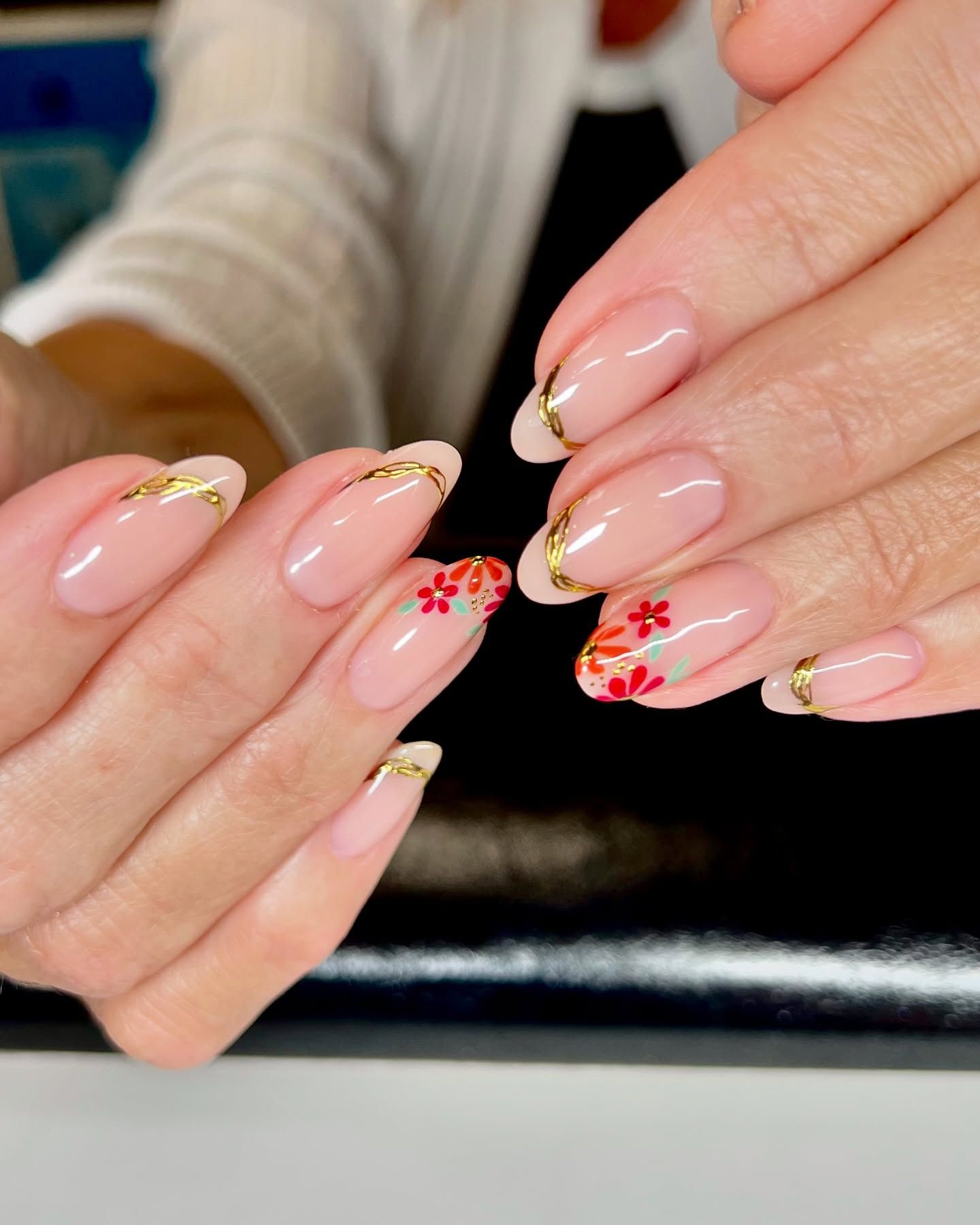 A close up of a woman 's nails with flowers on them