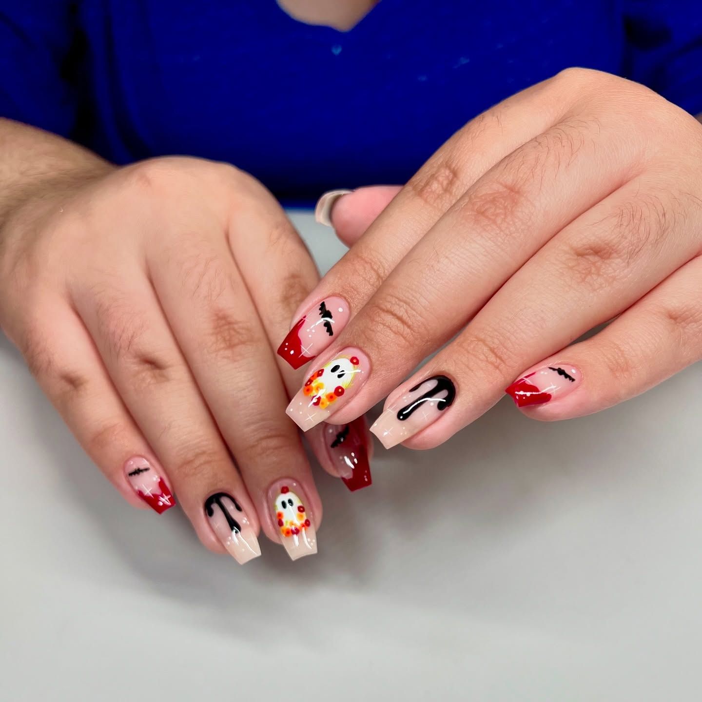 A close up of a woman 's nails with various designs on them