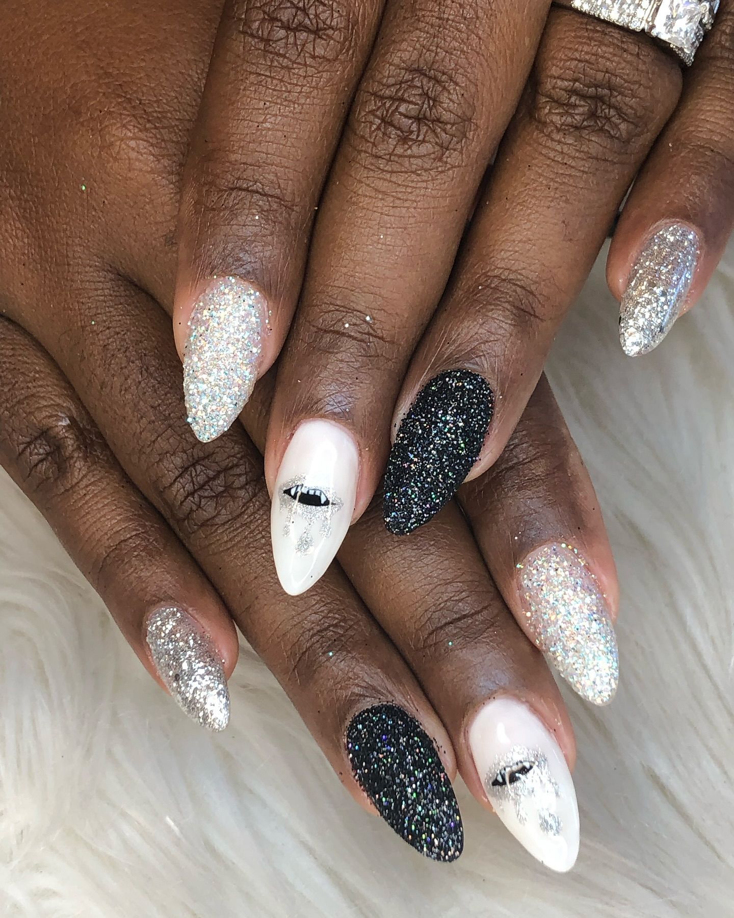 A close up of a woman 's nails with a black and white design