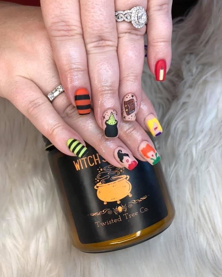 A close up of a woman 's nails with a candle in the background.