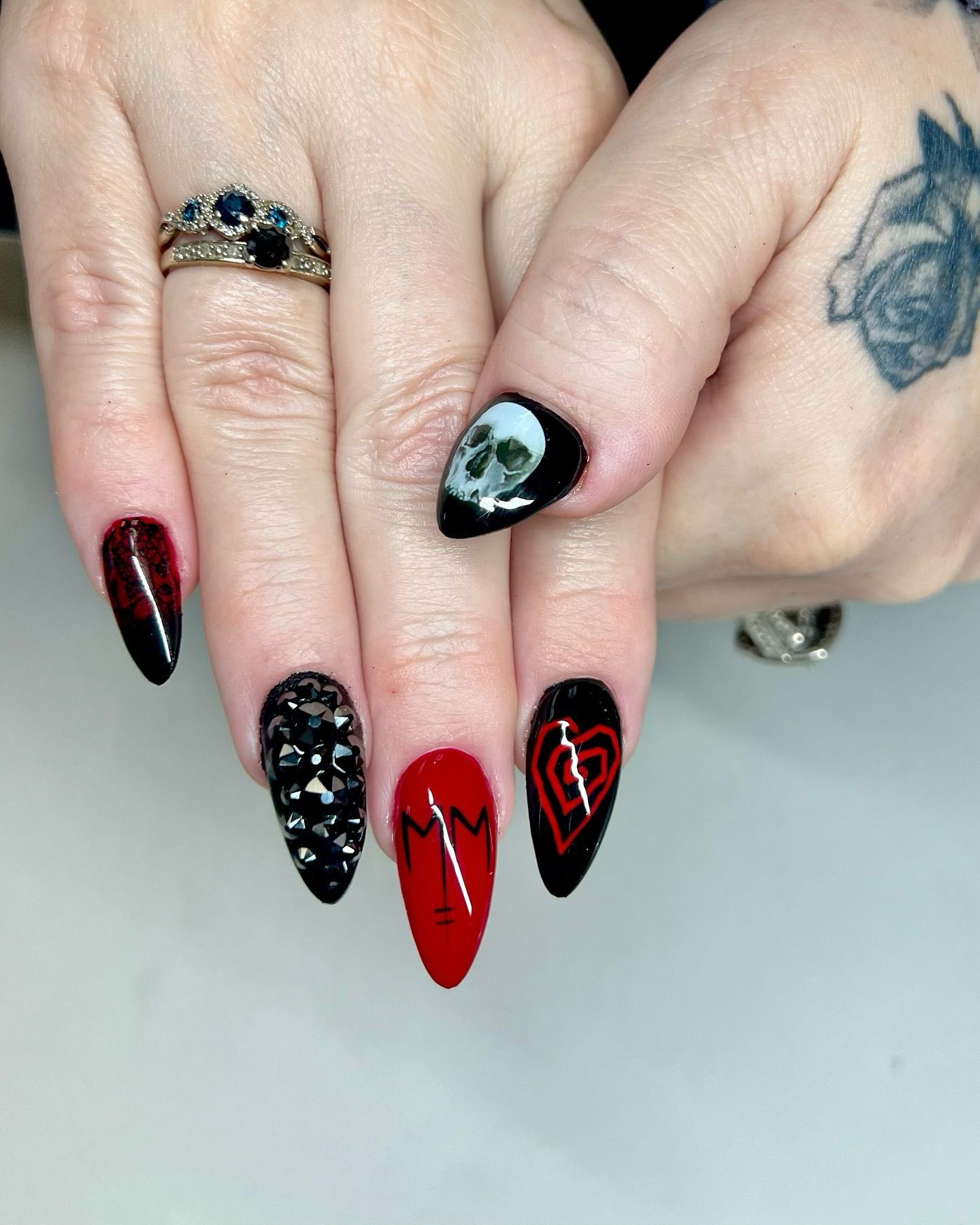 A close up of a woman 's nails with a tattoo on her hand