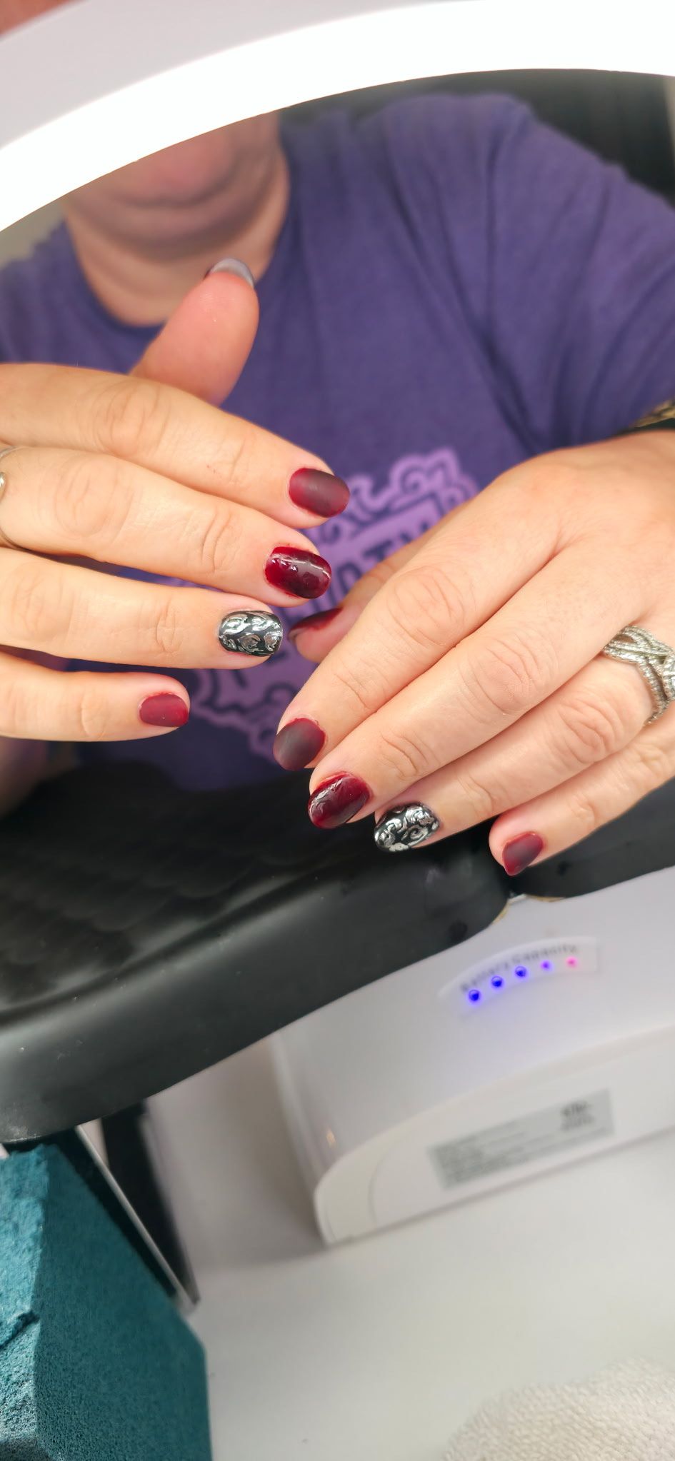 A woman is getting her nails done in front of a mirror.