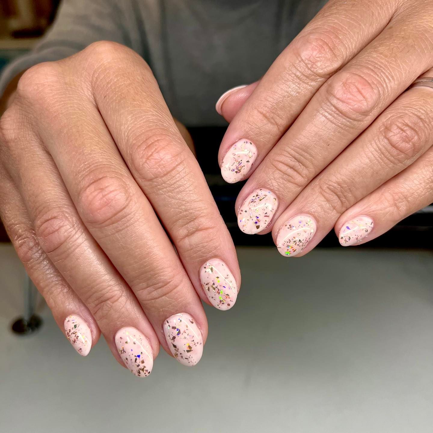 A close up of a woman 's nails with sprinkles on them.