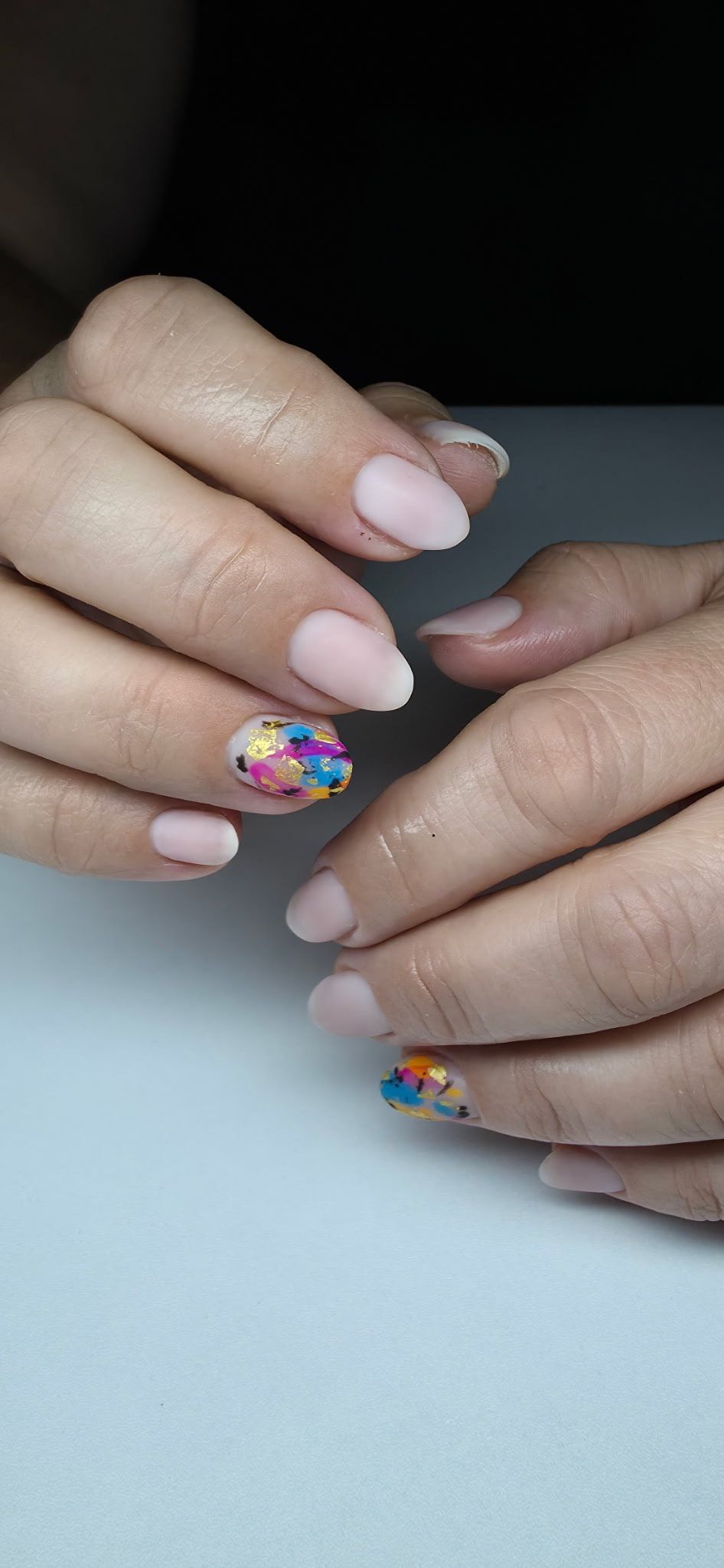 A close up of a woman 's nails on a table.