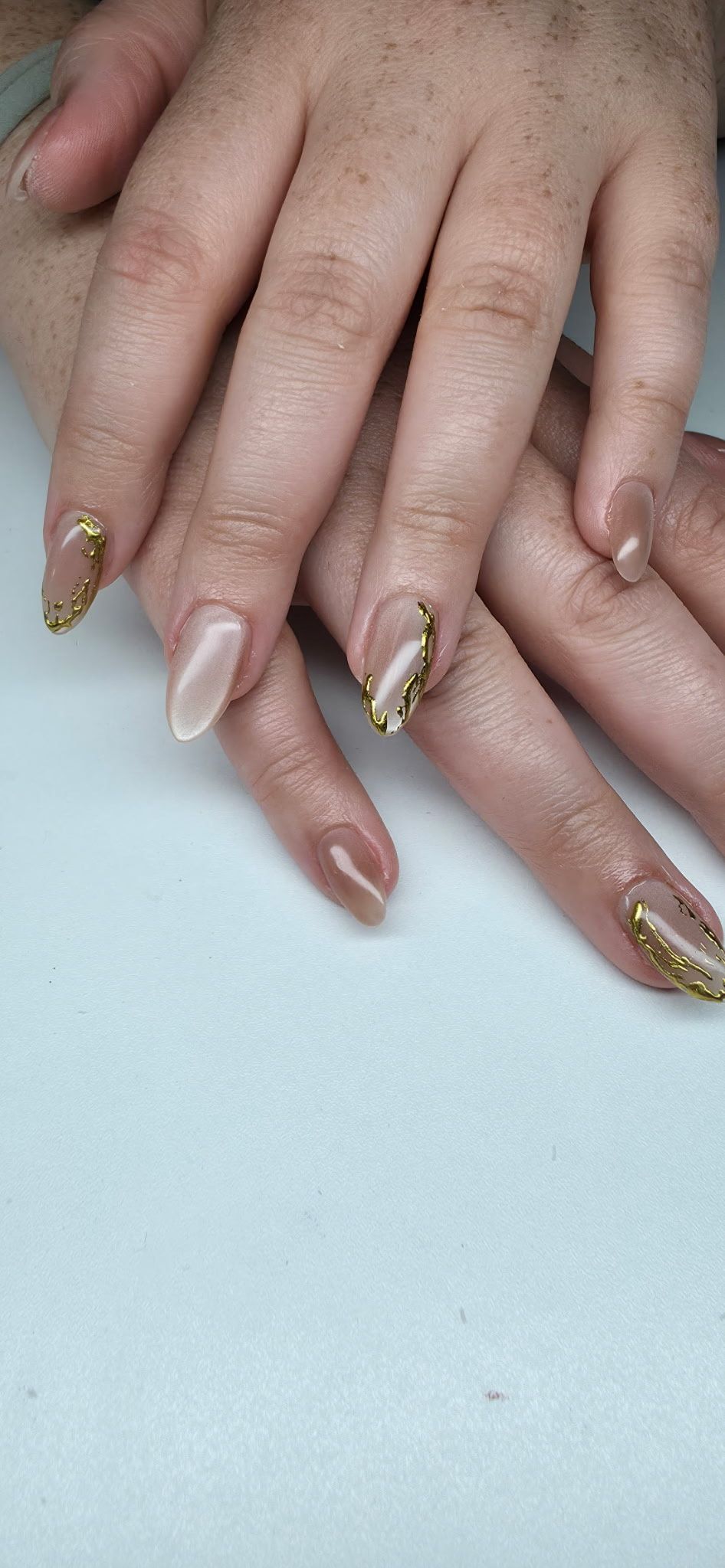 A close up of a person 's nails on a white surface.