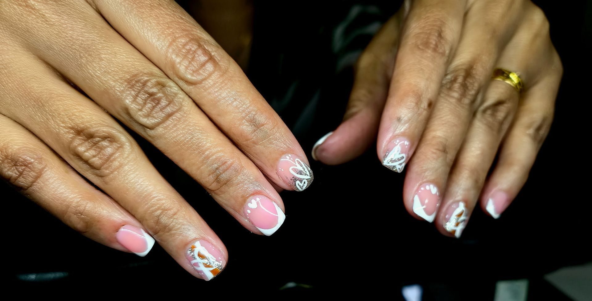 A close up of a woman 's nails with a ring on her finger