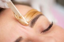 A woman is getting a waxing treatment at a spa.