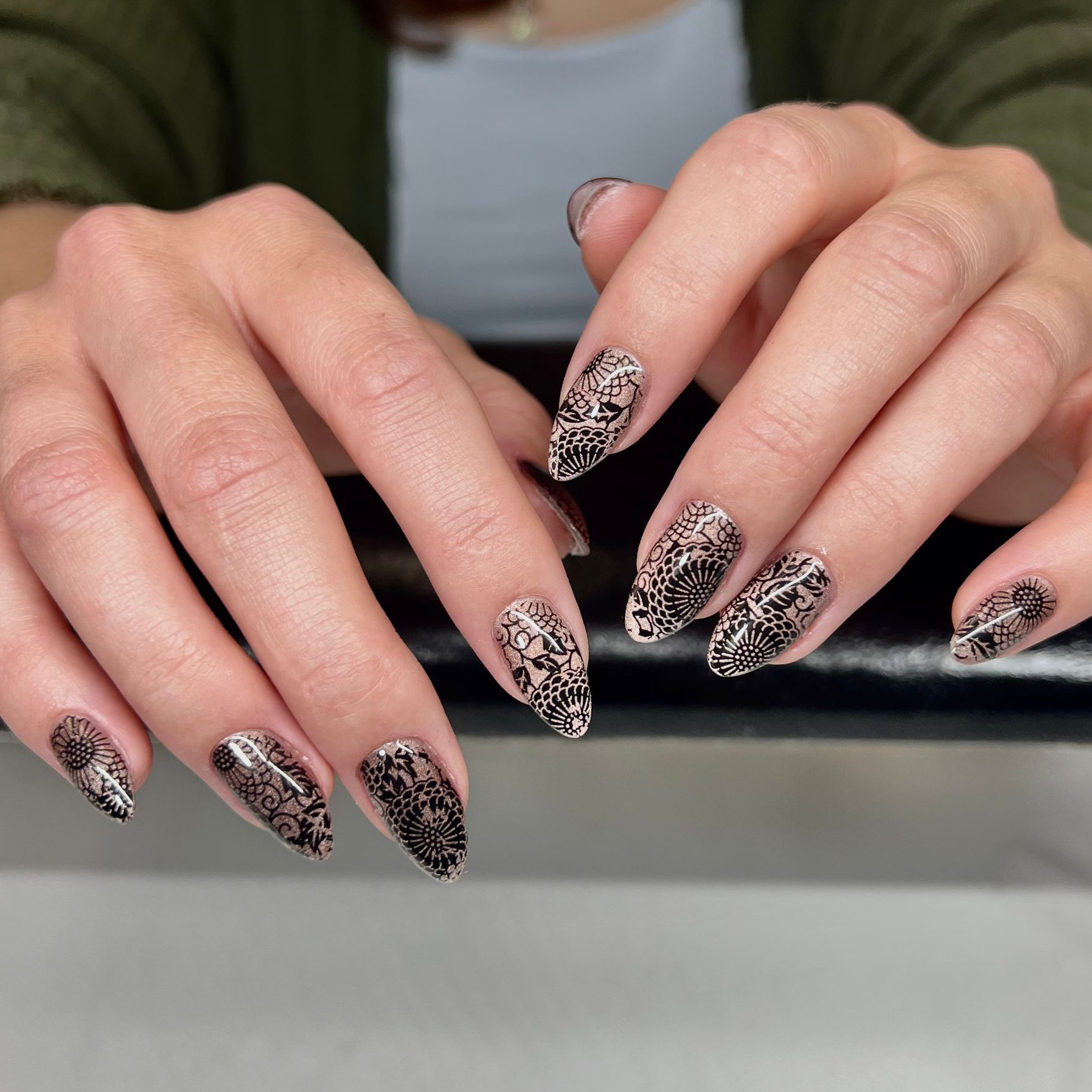 A person is posing for a picture of their nails with design.