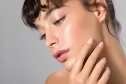 A close up of a woman 's face with her hand on her chin.