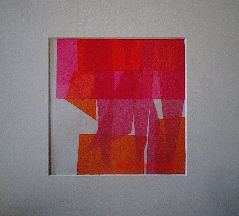 Un cuadro de cuadrados rojos y naranjas está enmarcado en una pared blanca.