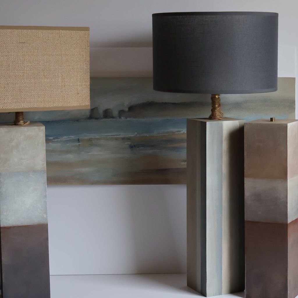 Dos lámparas están colocadas una al lado de la otra frente a un cuadro.