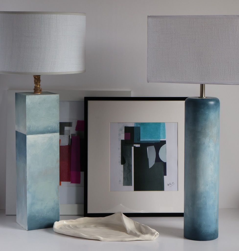 Una mesa con dos lámparas y un cuadro sobre ella.