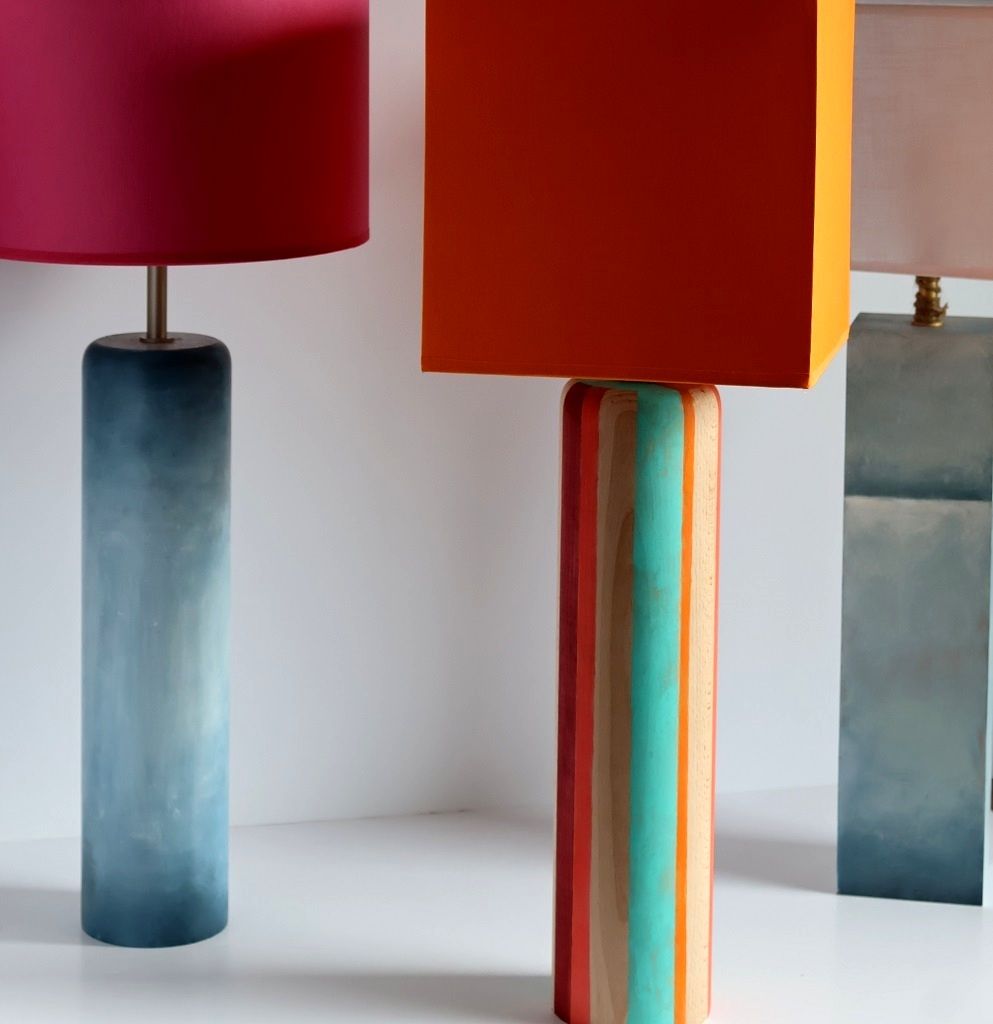 Tres lámparas de colores están colocadas una al lado de la otra sobre una mesa.