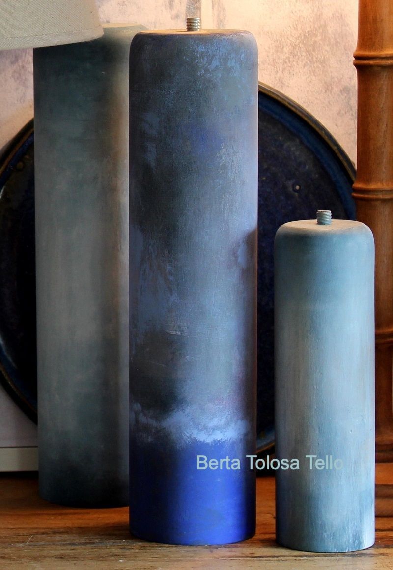 Tres velas azules están colocadas una al lado de la otra sobre una mesa de madera.