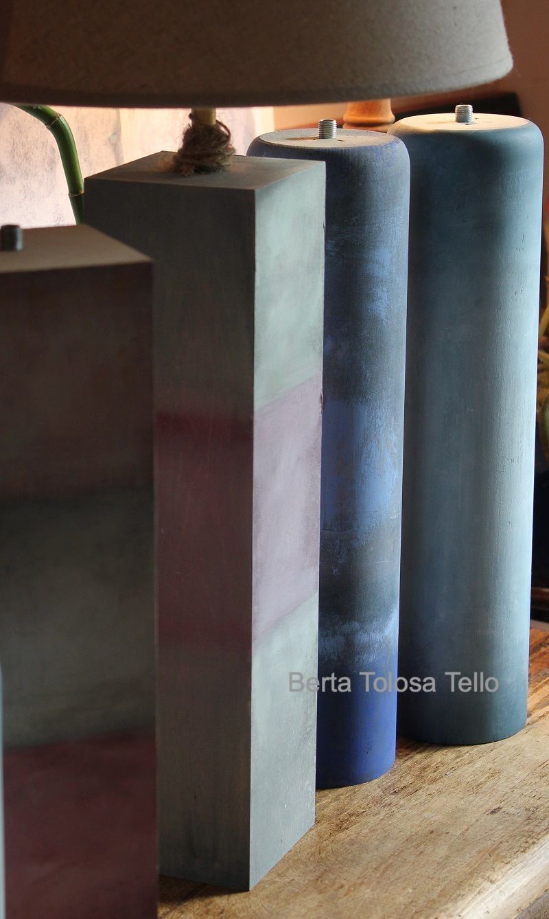 Una fila de velas están sobre una mesa al lado de una lámpara.