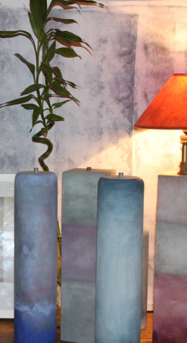 Una lámpara está sobre una mesa al lado de una planta.