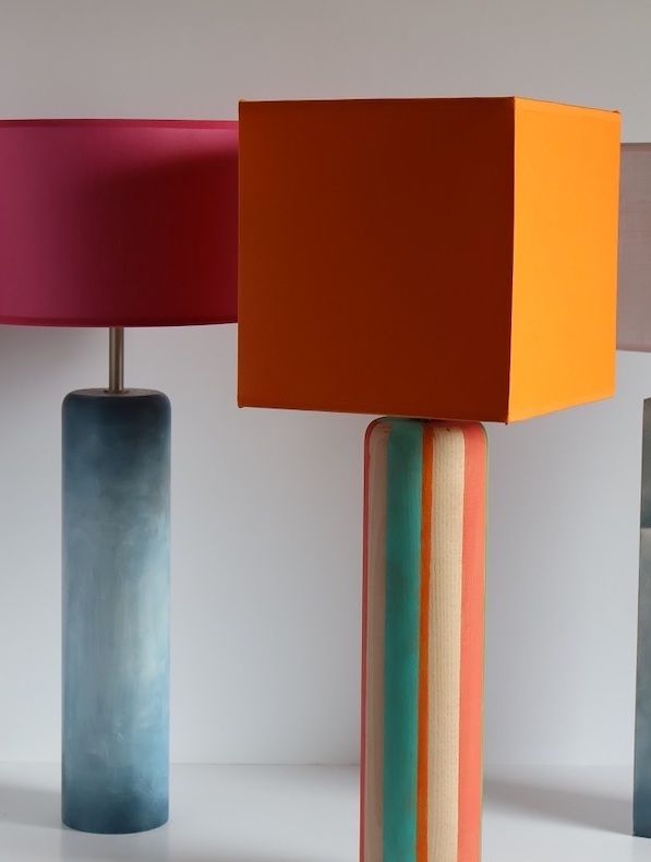 Tres lámparas de diferentes colores están alineadas sobre una mesa.