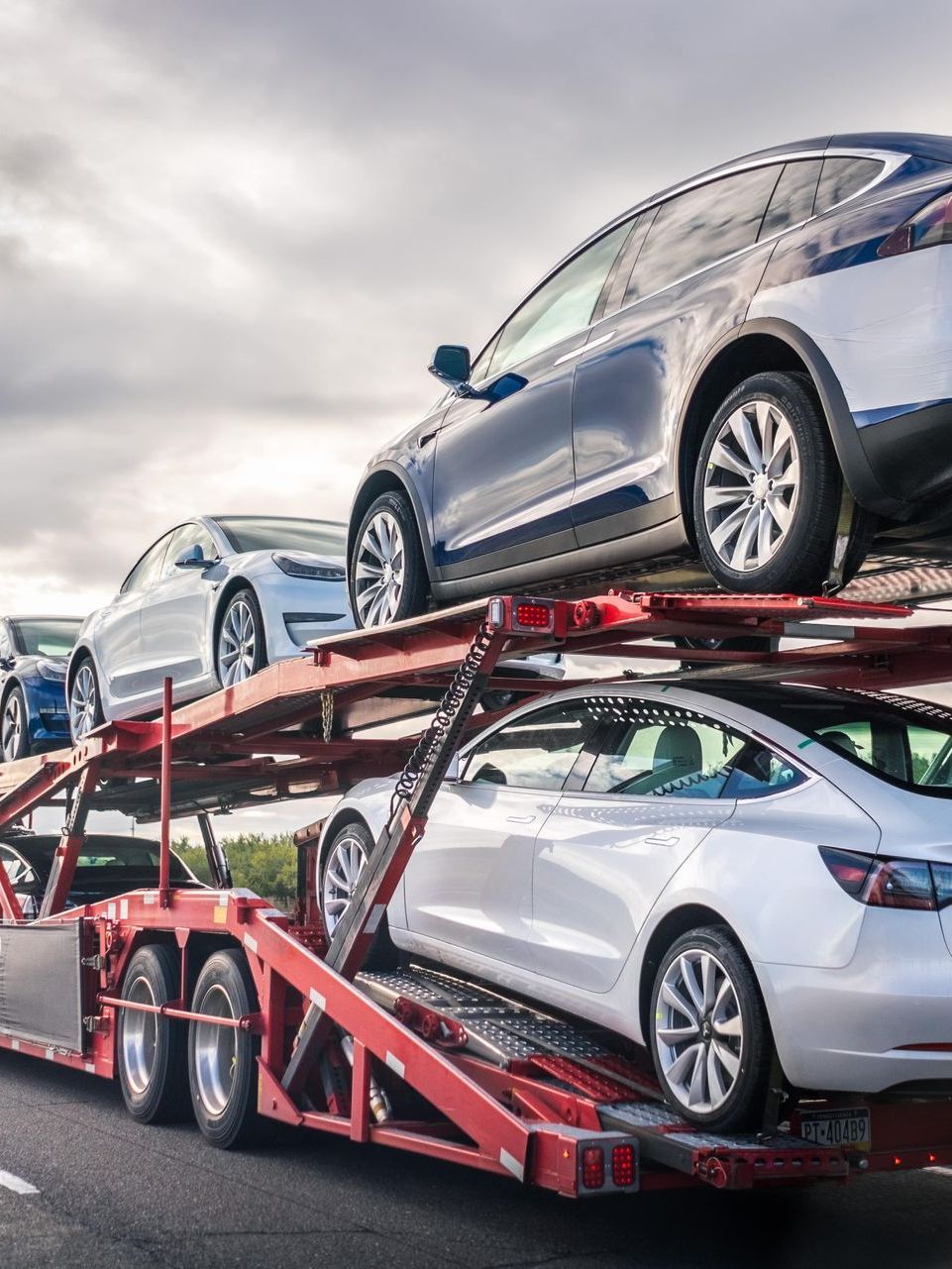 Two cars being transported on a truck