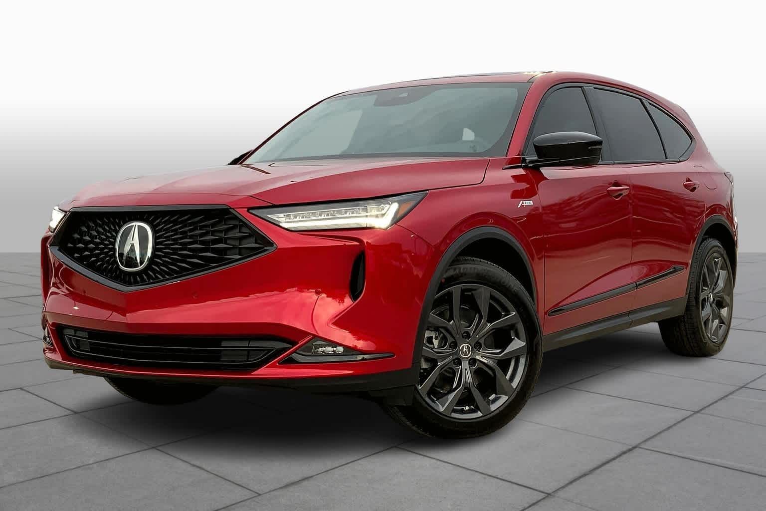 A red acura mdx is parked on a tiled floor.